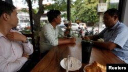 Men drink coffee and have breakfast at a coffee store in Phnom Penh, Cambodia July 19, 2018. (REUTERS/Samrang Pring)