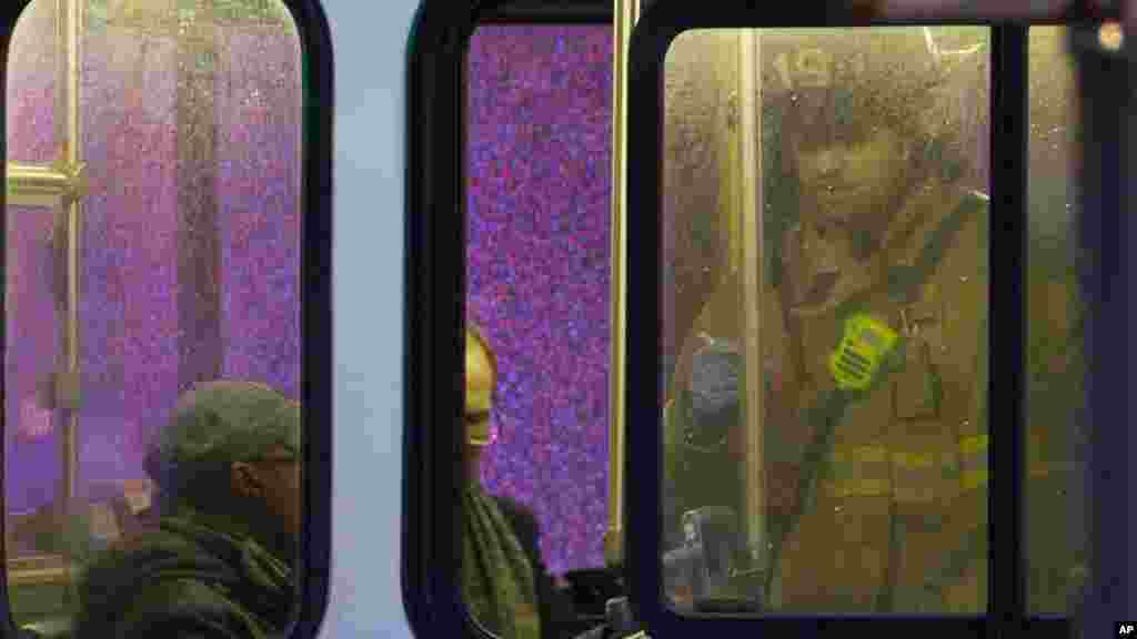 Un pompier assiste les passagers dans un bus après que ces derniers ont été évacués d&#39;un tunnel de métro enfumé à Washington, lundi 12 janvier 2015.