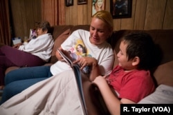 Therese Taylor reads a book to her son before bedtime. Beyond her immediate family, Taylor and her fiance, Andrew Saldivar, have hosted more than 20 people in their Houston home regularly since the storm cleared.