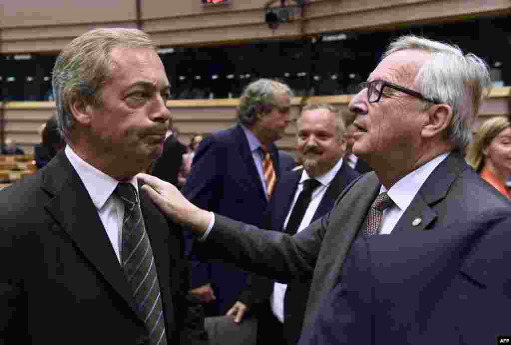 UK Independence Party (UKIP) leader Nigel Farage (L) talks with EU Commission President Jean-Claude Juncker before a plenary session at the EU headquarters in Brussels, Belgium. Juncker called on Prime Minister David Cameron to clarify quickly when Britain intends to leave the EU, saying there can be no negotiation on future ties before London formally applies to exit.