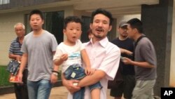 中國勞工權益活躍人士華海峰在江西贛州獲得釋放後抱著兒子離開（2017年6月28日）