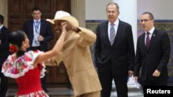 El canciller ruso, Serguei Lavrov, y su contraparte venezolano, Jorge Arreaza, observan a una pareja bailando una danza folklórica en Caracas, Venezuela, el viernes, 7 de febrero de 2020.