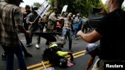 A man hits the pavement during a clash between members of white nationalist protesters against a group of counterprotesters in Charlottesville, Va,, Aug. 12, 2017. 