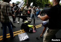 A man hits the ground during a clash between members of white nationalist protesters against a group of counterprotesters in Charlottesville, Va,, Aug. 12, 2017.