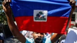 Yon manifestan ayisyen avèk yon drapo nan okazyon yon pwotestasyon pou mande demisyon Prezidan Jovenel Moise. (Foto Dosye).