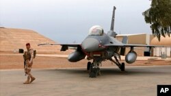 En esta foto del 13 de febrero de 2018, un soldado iraquí hace guardia cerca de un avión F-16 de la fuerza aérea iraquí en la base aérea Balad de Irak. La base fue impactada con cohetes el 12 de enero de 2020. AP/Khalid Mohammed.