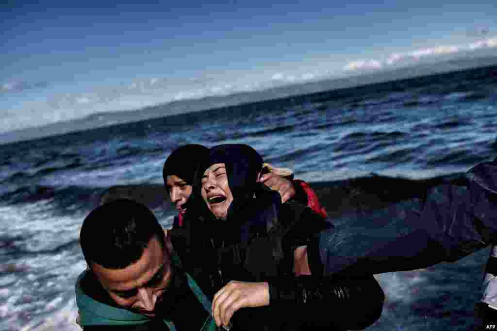 A man comforts a woman upon arrival with other refugees and migrants on the Greek island of Lesbos after they crossed the Aegean sea from Turkey. 