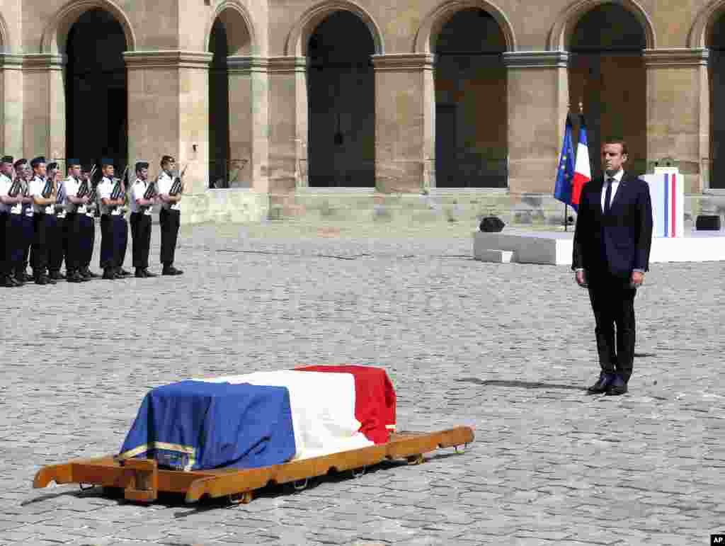 French President Emmanuel Macron stands in front of the flag-draped coffin of Simone Veil during a solemn funeral ceremony, in the courtyard of the Invalides in Paris. Holocaust survivors joined the president and European dignitaries at a special memorial ceremony for Simone Veil, who rose from the horrors of Nazi death camps to become president of the European Parliament and one of the country&#39;s most revered politicians.