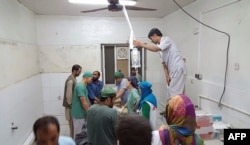 In this photograph released by Medecins Sans Frontieres (MSF) on October 3, 2015, Afghan MSF surgeons work in an undamaged part of the MSF hospital in Kunduz after the operating theatres were destroyed in an air strike.