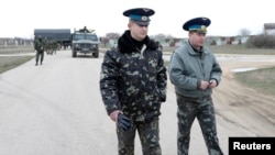 Ukrainian officers return after negotiations with Russian troops (L) at the Belbek airport in the Crimea region, March 4, 2014. 