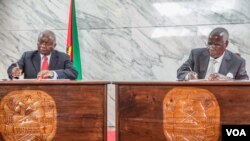 Presiden Mosambik Armando Guebuza (kiri) dan pimpinan oposisi Afonso Dhlakama menandatangani kesepakatan damai untuk mengakhiri konflik-konflik kecil selama dua tahun di negara itu (5/9/2014). 