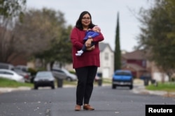 FILE - Blanca Eschbach, 32, poses for a portrait with her daughter Olivia on her first day back at work after a 10-week maternity leave in San Antonio, Texas, March 4, 2019.