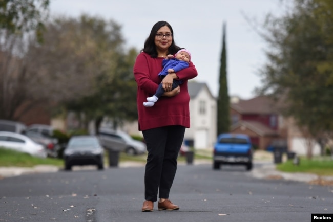 FILE - Blanca Eschbach, 32, poses for a portrait with her daughter Olivia on her first day back at work after a 10-week maternity leave in San Antonio, Texas, March 4, 2019.