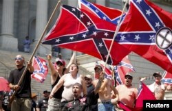 Members of the Ku Klux Klan yell as they fly Confederate flags during a rally at the South Carolina State House in Columbia, July 18, 2015.