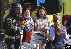 Injured people are treated in Barcelona, Spain, Aug. 17, 2017 after a white van jumped the sidewalk in the historic Las Ramblas district, crashing into a summer crowd of residents and tourists.