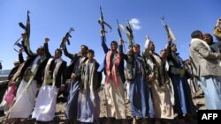 Armed Yemeni men raise their weapons as they gather near the capital Sanaa to show their support to the Shiite Houthi movement against the Saudi-led intervention, Feb. 21, 2019.