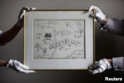 FILE - Sotheby's staff hold the original map of Winnie the Pooh's Hundred Acre Wood by E.H. Shepard at Sotheby's auction rooms in London, Britain, May 31, 2018.