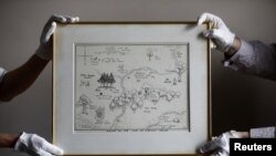 FILE - Sotheby's staff hold the original map of Winnie the Pooh's Hundred Acre Wood by E.H. Shepard at Sotheby's auction rooms in London, Britain, May 31, 2018.