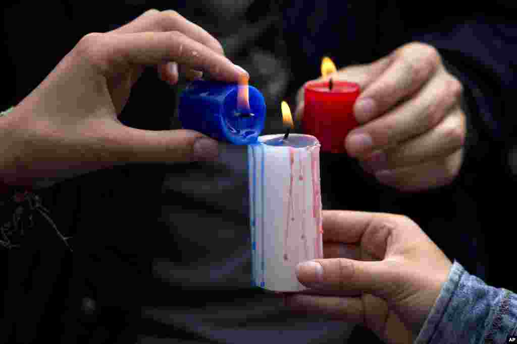 Des bougies aux couleurs de la France allumées devant l'ambassade française à Lima, au Pérou, au cours d'une cérémonie en hommage aux victimes des attentats meurtriers à Paris, 15 novembre 2015. 