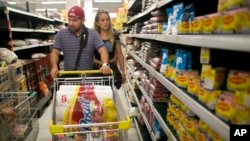 Venezuelan husband and wife Ramiro Ramirez and Tebie Gonzalez shop for food in Cucuta, Colombia, July 17, 2016, during the temporary opening of the border. U.S. firms doing business in Venezuela are adjusting accounting techniques.