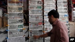 A man reads the morning newspaper displaying the front-page story of the disqualification of Prime Minister Nawaz Sharif by Supreme Court at a stall in Islamabad, July 29, 2017.