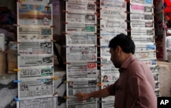 A man reads the morning newspaper displaying the front-page story of the disqualification of Prime Minister Nawaz Sharif by Supreme Court at a stall in Islamabad, July 29, 2017.