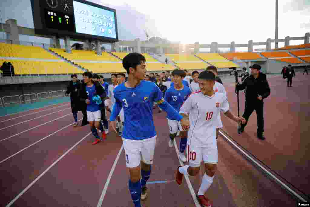 한국 춘천시에서 열린 제5회 아리스포츠 국제유소년 축구대회 개막전이 끝난 후 남북한 선수가 손을 잡고 뛰고 있다. 