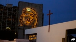 A sculpture of revolutionary hero Ernesto "Che" Guevara is lit up on a government building in Revolution Square beside an altar under construction ahead of Pope Francis' Mass in Havana, Cuba, Sept. 10, 2015. 