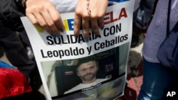 A supporter of jailed opposition leader Leopoldo Lopez holds a poster showing his face during an anti-government protest in Caracas, Venezuela, May 30, 2015. 