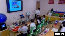 North Korean students learn and engage with a robot in Pyongyang, North Korea November 3, 2021, in this still image obtained from Reuters. (REUTERS TV/KRT)