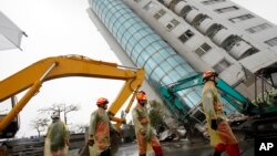 Rescuers work on a search operation at an apartment building that collapsed after a strong earthquake in Hualien County, eastern Taiwan, Feb. 7, 2018. A magnitude 6.4 earthquake struck late Tuesday night caused several buildings to cave in and tilt dangerously.