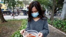 A woman prepares to release carps to Hoan Kiem lake on Kitchen God's Day as part of the traditional Vietnamese Lunar New Year celebrations, the biggest festival of the year in Hanoi, Vietnam February 4, 2021. REUTERS/Kham