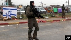 FILE - Israeli soldiers stand at the scene of an alleged stabbing attempt at Gush Etzion junction in the West Bank, Dec. 1, 2015. Near-daily violence has left more than 20 Israelis dead in the past three months.