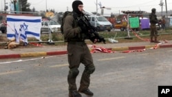 Israeli soldiers stand at the scene of an alleged stabbing attempt at Gush Etzion junction in the West Bank, Dec. 1, 2015.