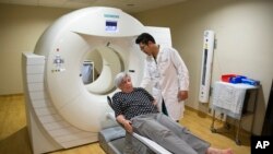 Judith Chase Gilbert, of Virginia., is loaded into PET scan machine by nuclear medicine technologist J.R. Aguilar as part of a study on Alzheimer's disease at Georgetown University Hospital, on Tuesday, May 19, 2015, in Washington, DC. (AP Photo/Evan Vucci)