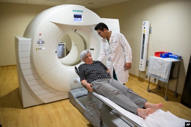 FILE - Judith Chase Gilbert, of Arlington, Va., is loaded into PET scan machine by Nuclear Medicine Technologist J.R. Aguilar as part of a study on Allheimer's disease at Georgetown University Hospital, on Tuesday, May 19, 2015, in Washington. (AP Photo/Evan Vucci