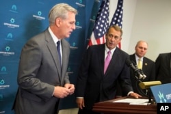 House Majority Leader Kevin McCarthy of Calif., left, accompanied by outgoing House Speaker John Boehner of Ohio, center, and House Majority Whip Steve Scalise of La. speaks during a new conference on Capitol Hill in Washington, Oct. 7, 2015.