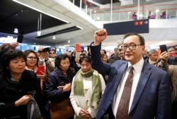 Cambodia's self-exiled opposition party founder Sam Rainsy, who has vowed to return to his home country, gestures to supporters after being prevented from checking-in for a flight from Paris to Bangkok at Roissy Airport in Paris, France November 7, 2019.