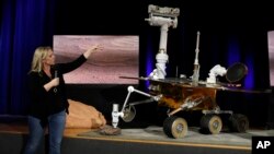 Mars 2020 project system engineer Jennifer Trosper points to a replica of the Mars rover Opportunity during a mission briefing at NASA's Jet Propulsion Laboratory, Feb. 13, 2019, in Pasadena, Calif.