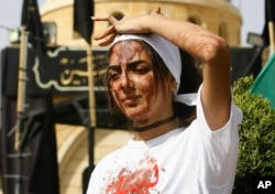 A Lebanese Shi'ite woman bleeds from self-inflicted head wounds to show her grief during Ashura rituals in Nabatieh, Oct. 12, 2016.