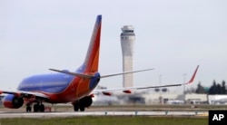 FILE - A Southwest Airlines jet waiting to depart in view of the air traffic control tower at Seattle-Tacoma International Airport, April 23, 2013.