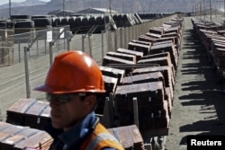 FILE - An operator monitors a train yard where copper cathodes are loaded for shipping to a port, at the Chuquicamata mine and foundry in northern Chile, April 1, 2011.
