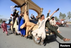 People celebrate a cease-fire in the Rodat district of Nangarhar province, Afghanistan, June 16, 2018.