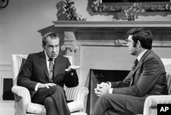 FILE - President Richard Nixon talks with correspondent Dan Rather before an interview at the White House, Jan. 2, 1972. Nixon avoided impeachment proceedings by resigning from office in the face of the Watergate scandal.