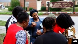 Members of Mount Olive Baptist Church pray near a municipal building that was the scene of a shooting, June 1, 2019, in Virginia Beach, Va. (AP Photo/Patrick Semansky)