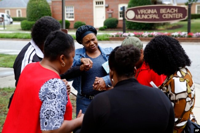 Members of Mount Olive Baptist Church pray near a municipal building that was the scene of a shooting, June 1, 2019, in Virginia Beach, Va