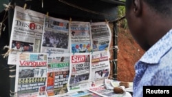 Newspapers with various front page headlines on the Chibok girls and their possible release are displayed at a news stand in Abuja, Nigeria, Oct. 18, 2014.