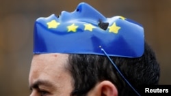 An anti-Brexit protester wears a EU face mask on his head outside the Houses of Parliament in London, Nov.14, 2017. 
