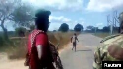 Homens vestidos com farda militar disparam contra uma mulher nua, junto à vila de Diaca, em Cabo Delgado, Moçambique 