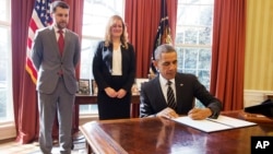 باراک اوباما در حال امضای فرمان اجرایی در دفتر کار خود در کاخ سفید - ۲۹ اسفند ۱۳۹۳ 